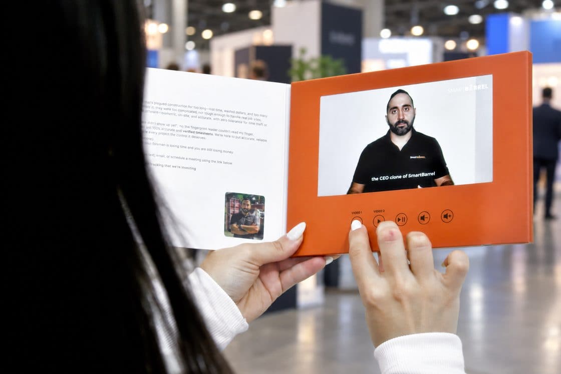 Dispositivo abierto con la pantalla encendida, en manos de una persona en una feria